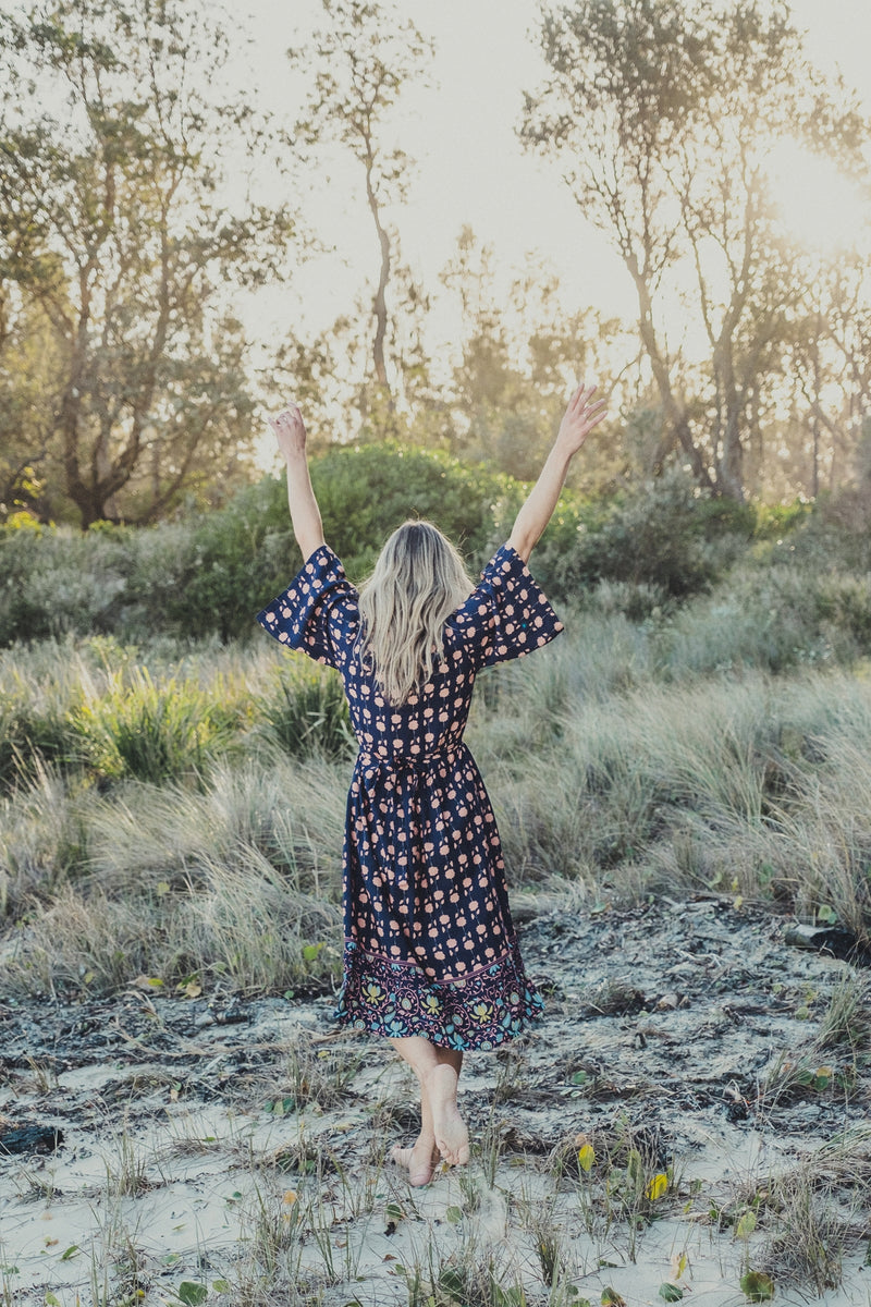 a vintage inspired bell sleeve midi length dress with a sqaure neckline in a navy and peach floral rayon voile with a decorative border at Jipsi Cartel boutique in Milton NSW