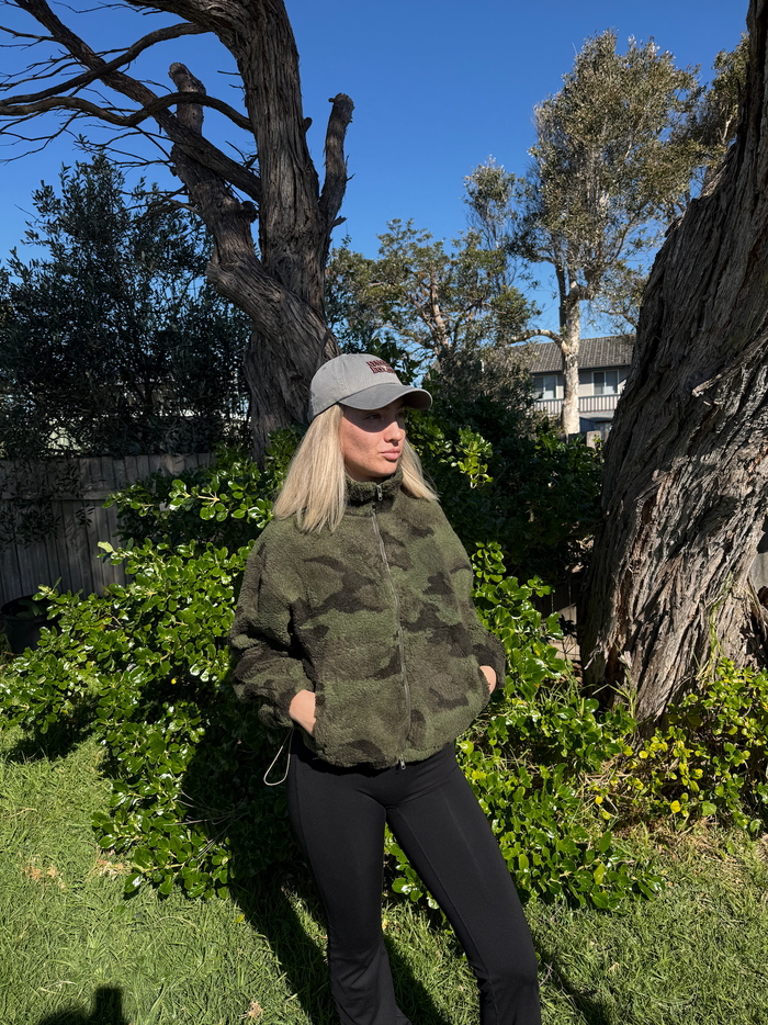 The ultimate comfort in the Camo Teddy Bomber Jacket By Frankie. Crafted from cozy sherpa fleece fabric, it's the perfect layering piece for winter.