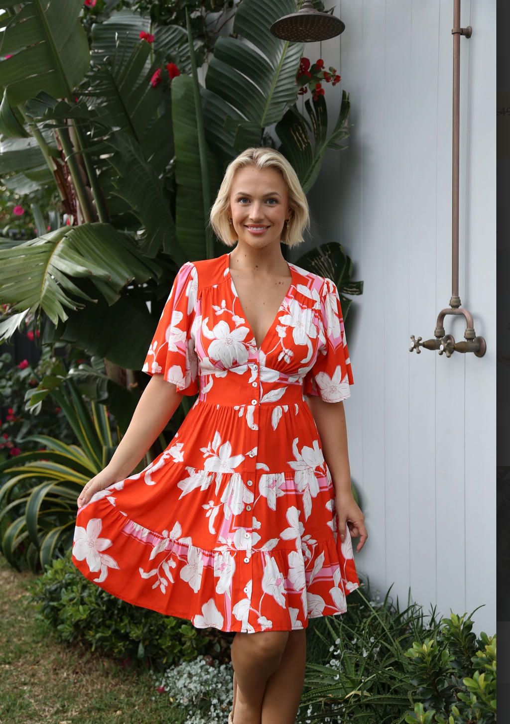 the hibiscus dress from salty bright is a red and pink floral boho casual dress