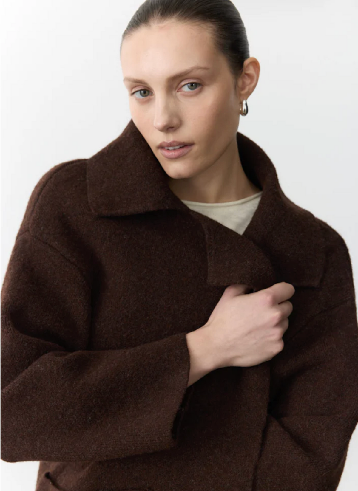 Woman wearing a brown coat by little lies
