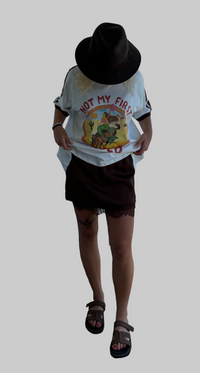 not my first rodeo tee by frankie is a white cotton tee with a mermaid riding a horse in a desert sccene with contrast sleeve stripes