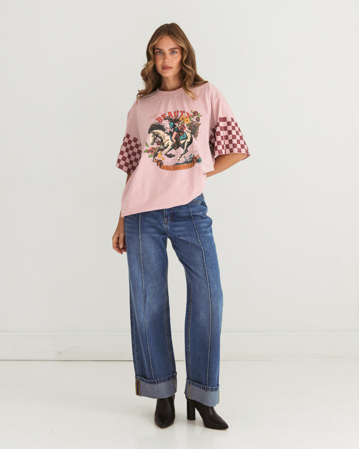 saddle up beauty tee by paper heart is a pink cotton t-shirt with contrats check sleeves and cowgirl image on the front