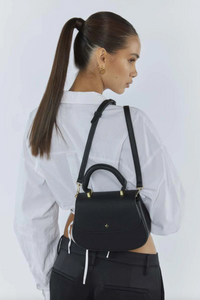 amalie crossbody bag by peta and jain is a vegan leather bag with a top handle in black