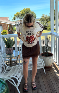 most wanted tee by frankie is a cotton t-shirt with a flaming heart and gun image