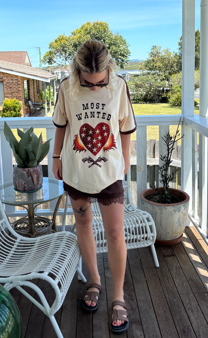 most wanted tee by frankie is a cotton t-shirt with a flaming heart and gun image