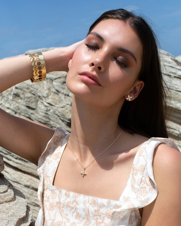 desert flower yellow gold stud earrings by murkani have mother of pearl and white topaz